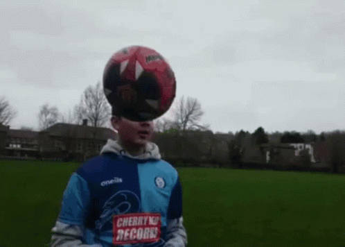 Boy with Soccer Ball on Head in Cherry Records Shirt