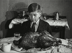 Boy With Turkey On Table GIF