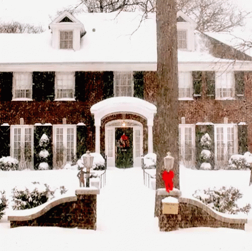 Brick House Covered in Snow With Red Bow on Door