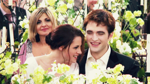 Bride And Groom Holding Hands With Man In Suit Behind GIF
