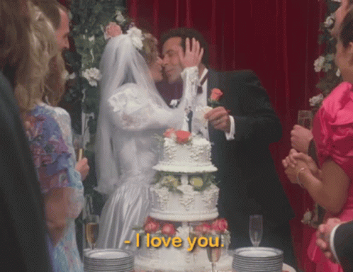 Bride And Groom Kiss In Front Of I Love You Cake GIF