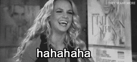 Britney Spears Is Laughing In A Black And White Photo While Standing In Front Of A Sign . GIF