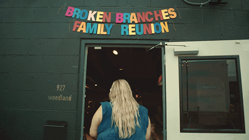 Broken Branches Family Reunion Is Advertised On A Black Building GIF