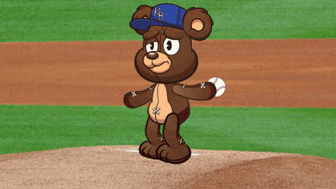 Brown Teddy Bear in Blue KB Hat on Baseball Field