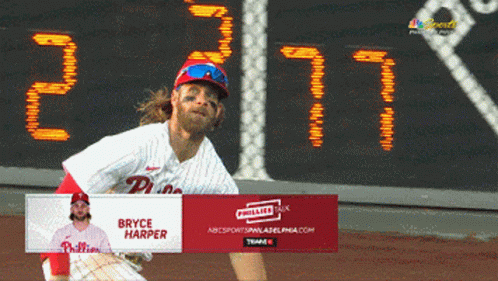 Bryce Harper Throws A Ball In Front Of A Scoreboard GIF