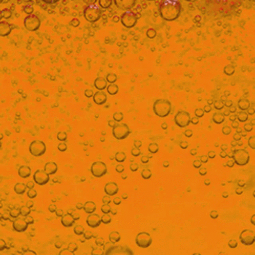 Bubbles Are Floating In A Yellow Liquid GIF