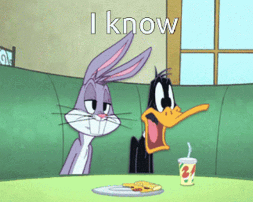 Bugs Bunny And Daffy Duck Sit At A Table With A Plate Of Food GIF