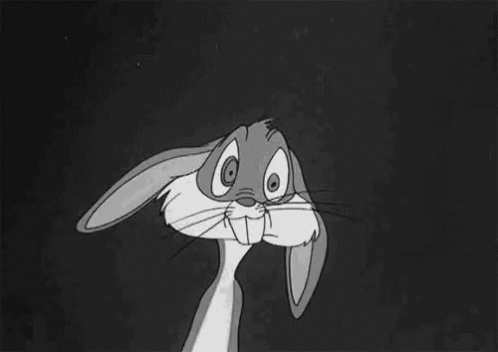 Bugs Bunny From The Looney Tunes Cartoon Is Sitting Down With His Hands Folded In Front Of His Face . GIF