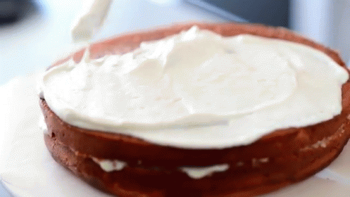 Cake Being Frosted With Whipped Cream