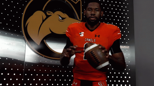 Camels Football Player Holding Football