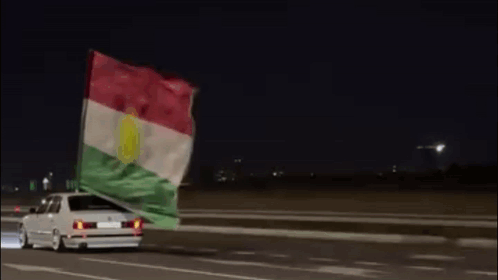 Car Driving At Night With Flag GIF
