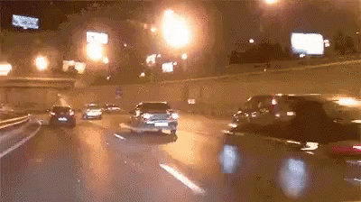 Car Driving Down Highway at Night With Lights