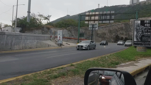 Car Driving Down Road Next to Sign Saying #wepro