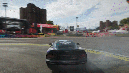 Car Driving Down Road With Building and Hot Air Balloon