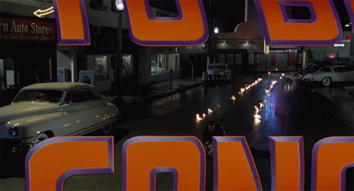 Car Driving Down Street Past Ruth Store