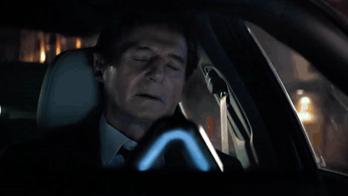Car Driving Down Wet Street at Night With No Parking Sign