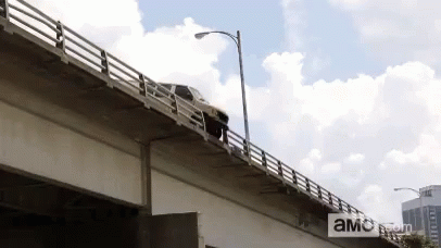 Car Driving Over Bridge With AMC.com Sign