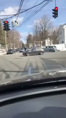 Car Driving Through Busy Intersection With Red Light