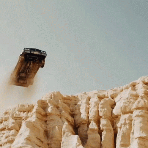 Car With Dusty Tires Driving Off Cliff GIF