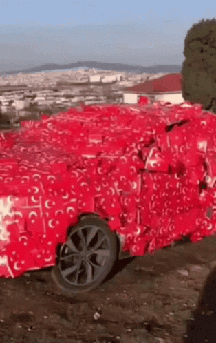 Car Wrapped in Red Tissue Paper in Dirt