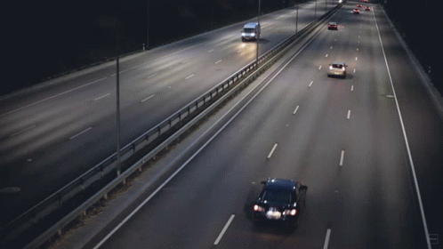 Cars Are Driving Down A Highway At Night And One Of Them Is A Yellow Car GIF