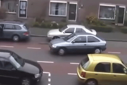 Cars Driving Down Street Including Yellow One