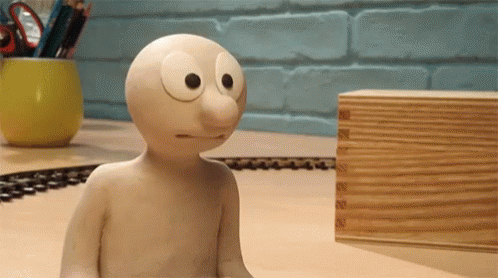 Cartoon Character Sitting on Table Next to Wooden Box