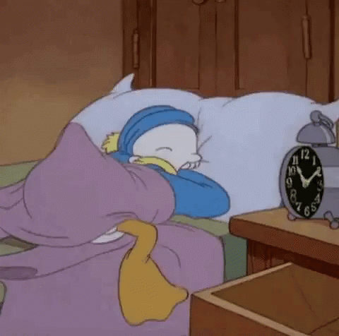 Cartoon Character Sleeping on Bed Next to Clock