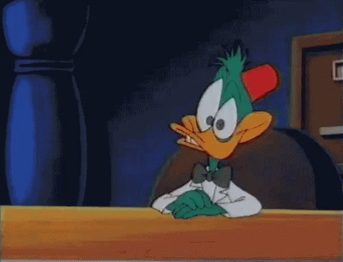 Cartoon Duck in Tuxedo Sitting at Table
