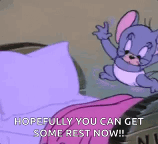 Cartoon Mouse Sitting On Bed With Pink Blanket And Purple Pillow GIF