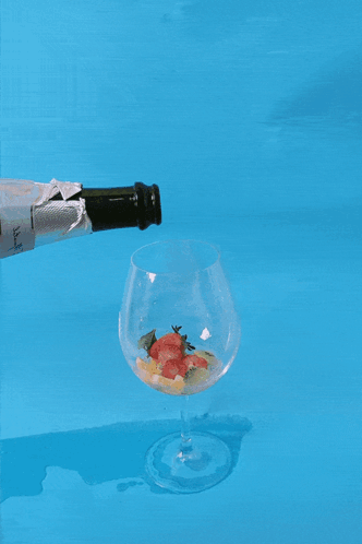 Champagne Poured Into Glass on Blue Surface