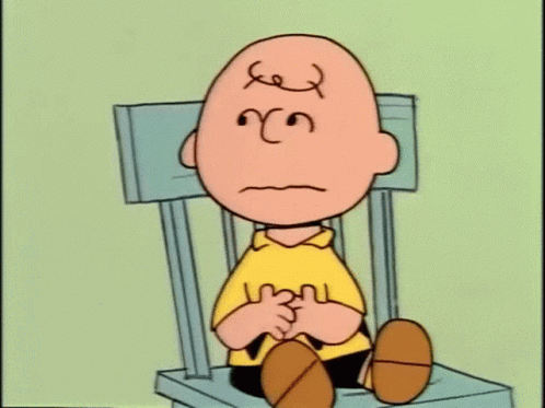 Charlie Brown Is Sitting On A Chair With A Sad Face On His Face . GIF