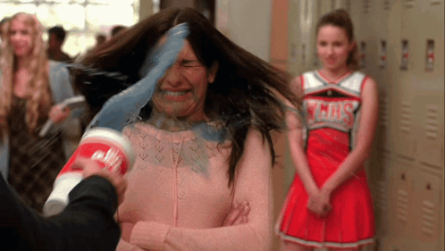 Cheerleader in Gray Uniform Behind Woman With Cup on Head