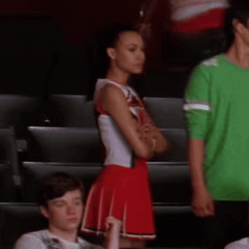 Cheerleader in Red and White Uniform Next to Man in Green Shirt