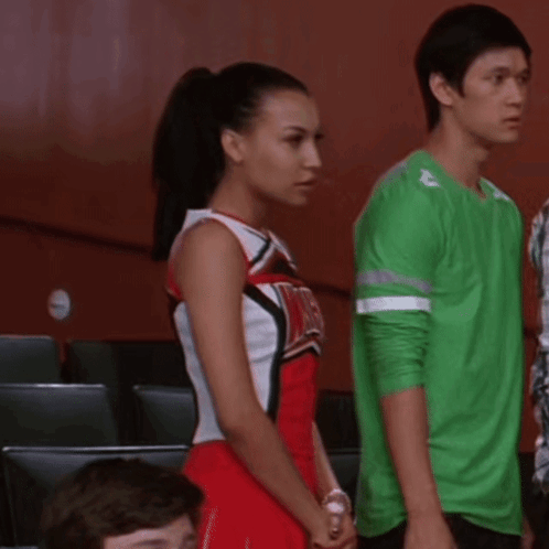 Cheerleader in Red and White Uniform with WMHS Beside Man in Green Shirt