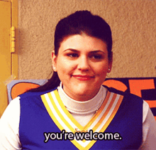 Cheerleader Saying You're Welcome in Front of Sign