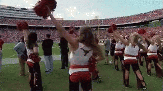 Cheerleaders Holding Pom Poms on Football Field