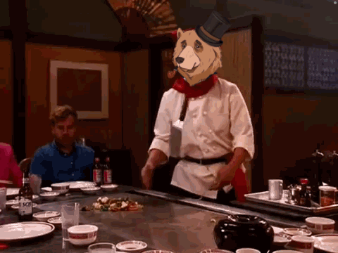 Chef in Top Hat With Bear Head at Table