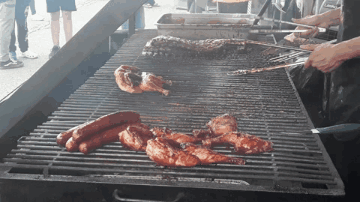 Chicken and Sausages Cooking on Grill