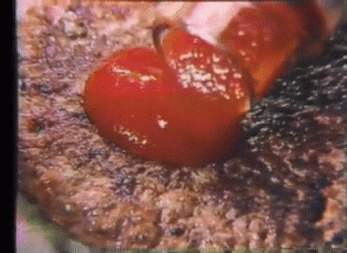 Child Adding Ketchup To Meatloaf GIF
