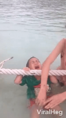 Child Crying in Water Pulled by Rope