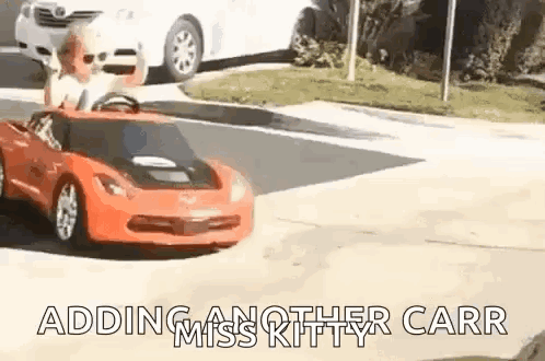 Child Driving Red Toy Car