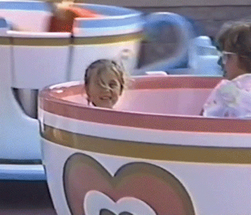 Child Riding Pink and White Tea Cup With Heart