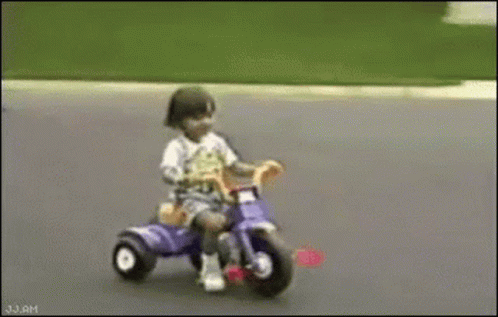 Child Riding Purple Tricycle