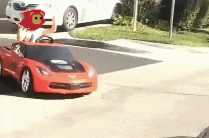 Child Riding Red Toy Car on Street