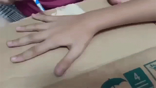 Child's Hand on Cardboard Box With Number 4