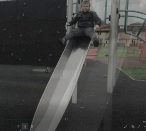 Child Sitting on Slide With Green Arrow
