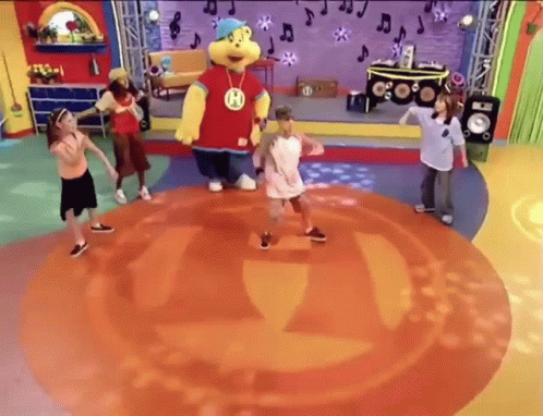 Children Dancing On Stage With Mascot Wearing H GIF