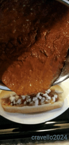 Chili Dog Being Poured on Plate 2024