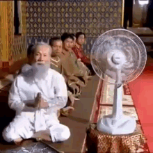 Chinese Monk Switching On Electric Fan GIF